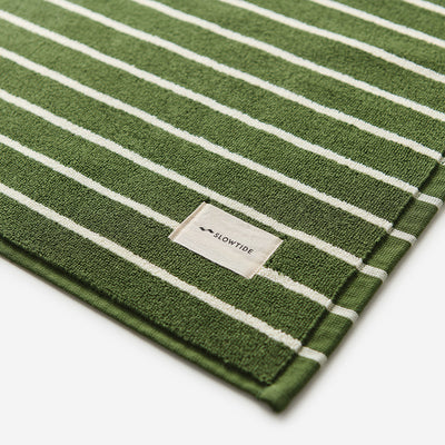 Cotton towel with green and white stripes, absorbent bath mat style.