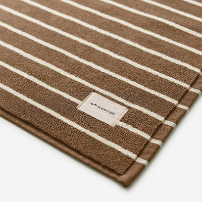 Brown cotton towel with white stripes, sustainable material, absorbent fabric.