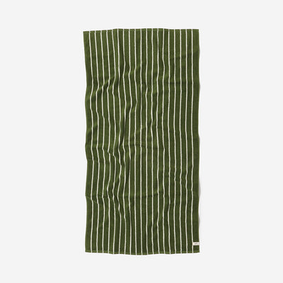 Sand resistant towel with green and white vertical stripes, slightly wrinkled.