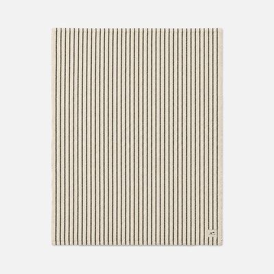 Beige rug with thin black vertical stripes, textured surface.
