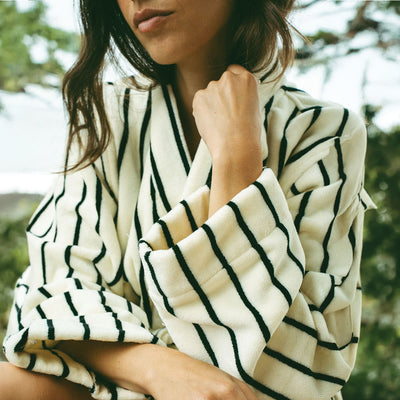 Plush robe in cream with black vertical stripes.
