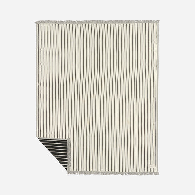 Cotton blanket with thin black stripes, fringed edges, and visible reverse corner.