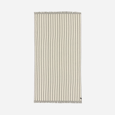 Turkish towel, lightweight beige cotton with thin black stripes and fringe on short ends.