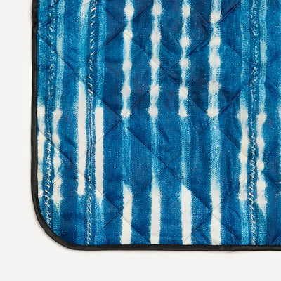 Quilted water-resistant mat featuring blue and white vertical tie-dye stripes.