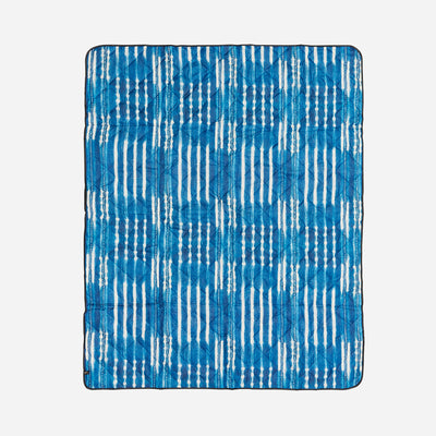 Blue and white patterned quilt on a light gray background