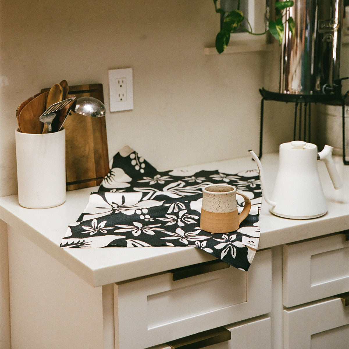 Recycled microfiber kitchen towel with floral pattern under mug and kettle.