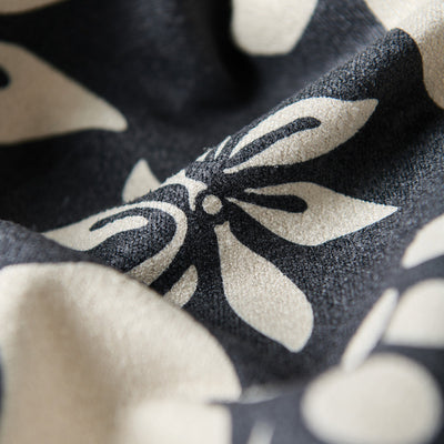 Eco-friendly kitchen towel with black and white bold floral pattern, close-up texture view.