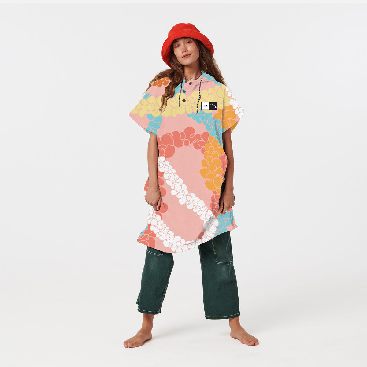 Floral towel poncho with red bucket hat and green pants, displayed on white background.