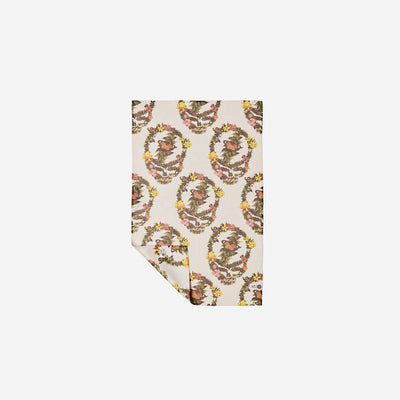 Kitchen towel with beige floral botanical print, partially folded on white background.