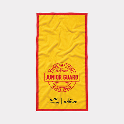 Beach towel in yellow quick-dry fabric with red trim and Junior Guard North Shore graphic.