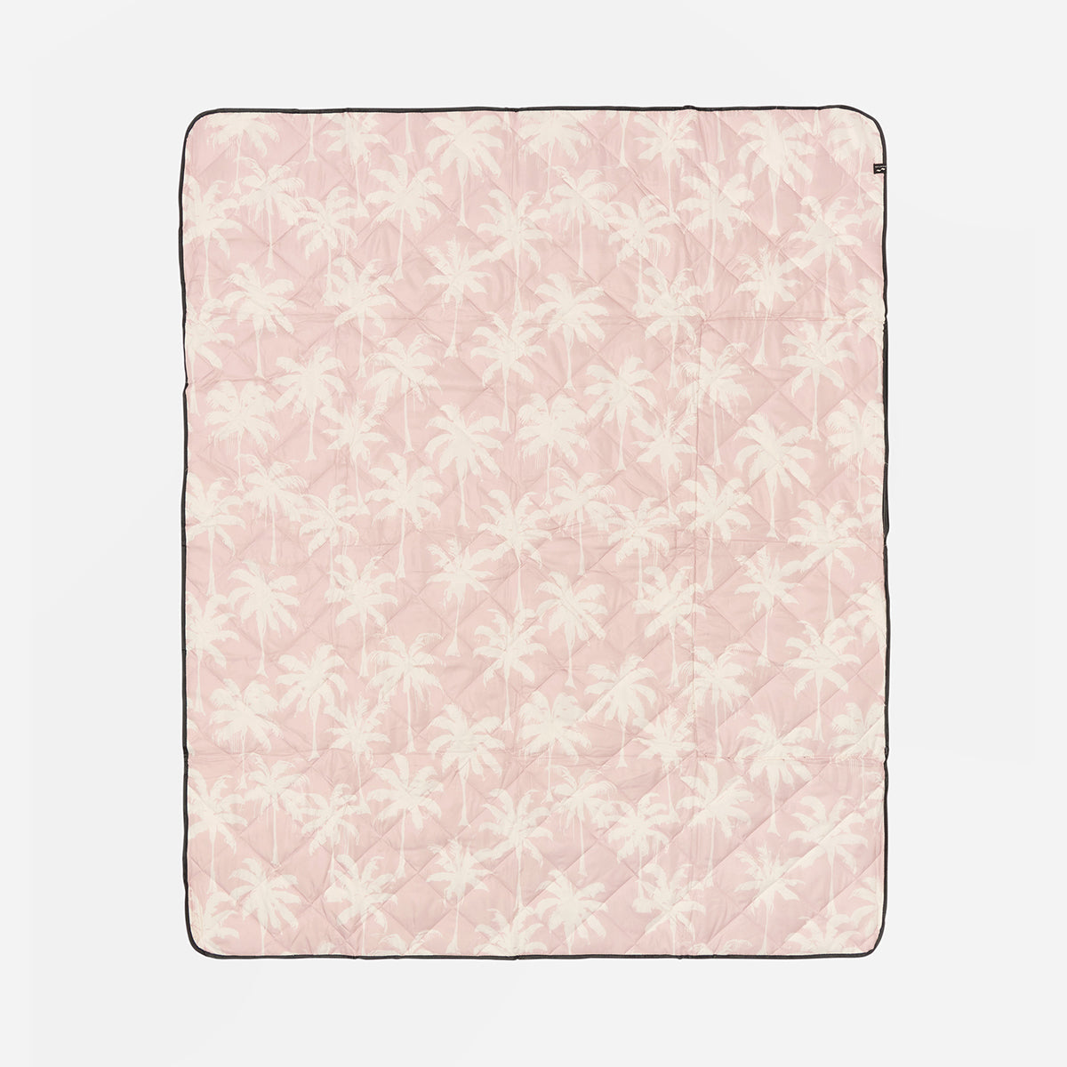 Pink blanket with white floral pattern on a light pink background