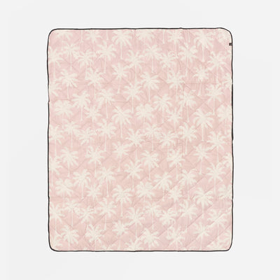 Pink blanket with white floral pattern on a light pink background