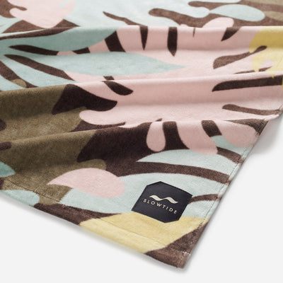 Velour towel with pastel leaf print and corner label.