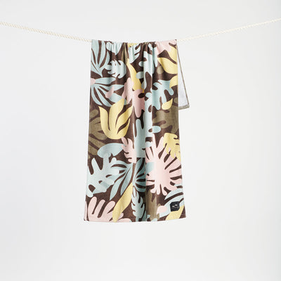 Velour towel with tropical print, absorbent cotton finish, shown hanging on a rope.