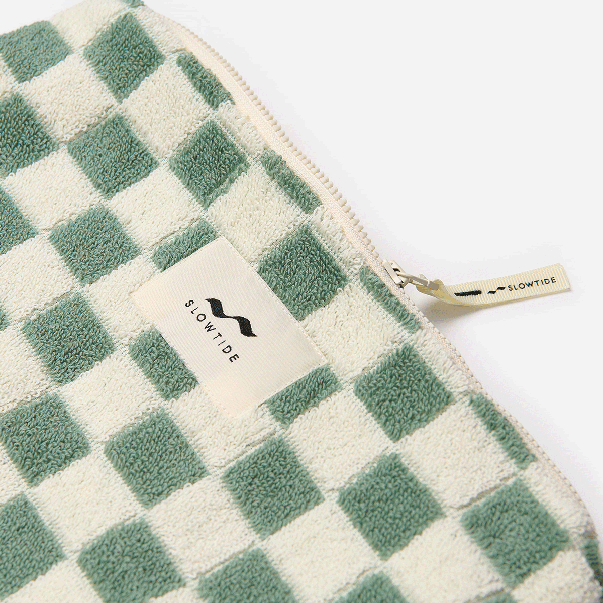 Terry pouch with green and white checkered pattern and zipper tag.