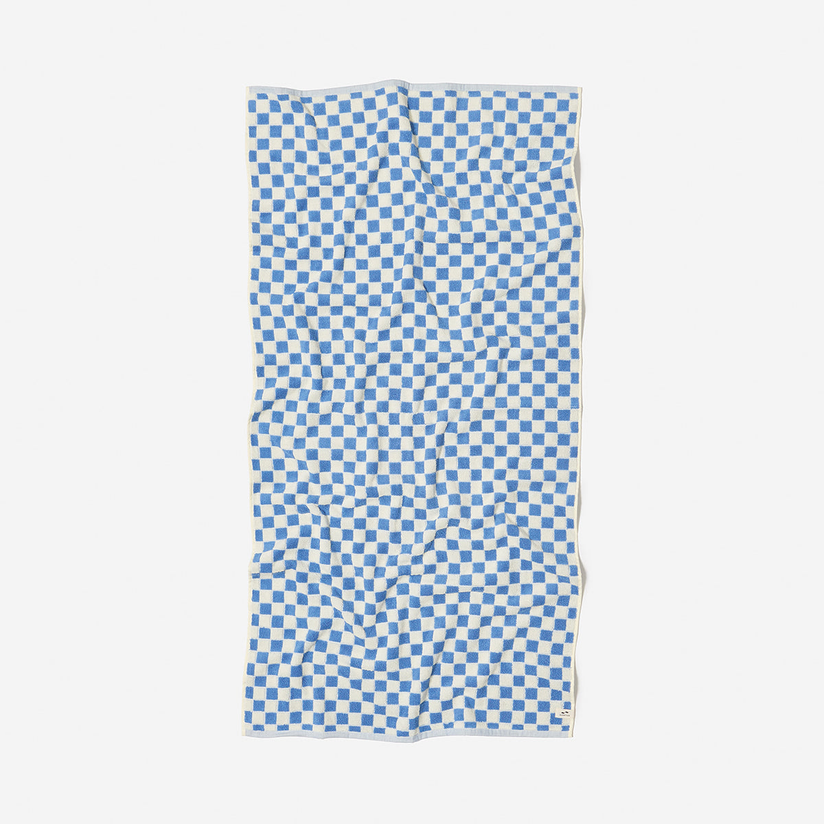 Cotton terry bath towel with blue and white checkerboard pattern laid flat.