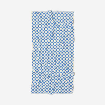 Cotton terry bath towel with blue and white checkerboard pattern laid flat.