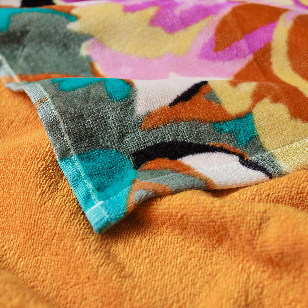 Velour towel with colorful abstract orange, green, pink, and blue pattern.