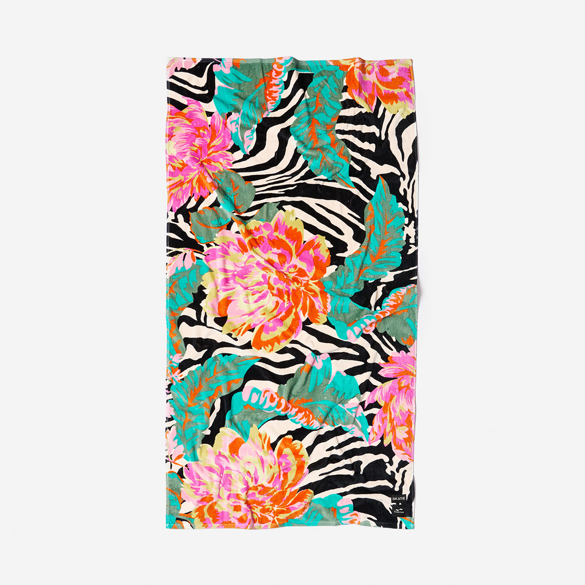 Beach towel with zebra stripes, colorful flowers, and green leaves on white background.