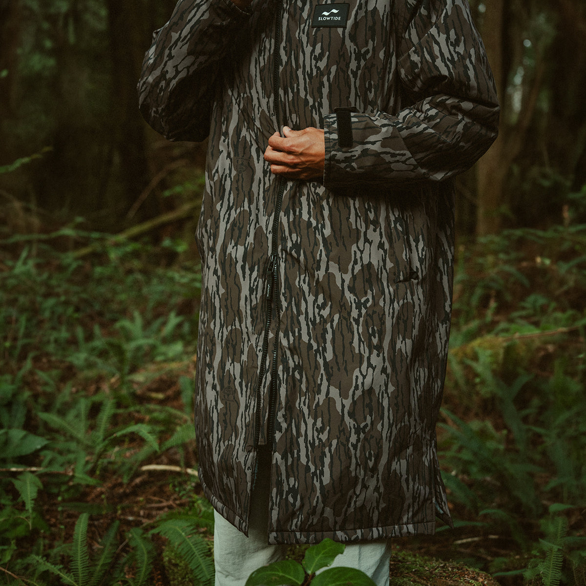 Camo parka with insulation and waterproof design for outdoor wear.