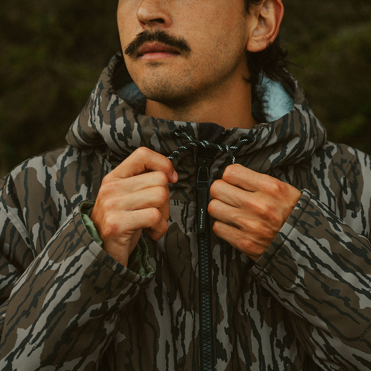 Insulated jacket with front zipper closure, outdoor setting.