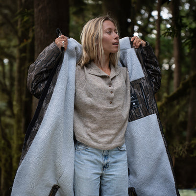 Insulated jacket layered over sweater and jeans, outdoor setting.