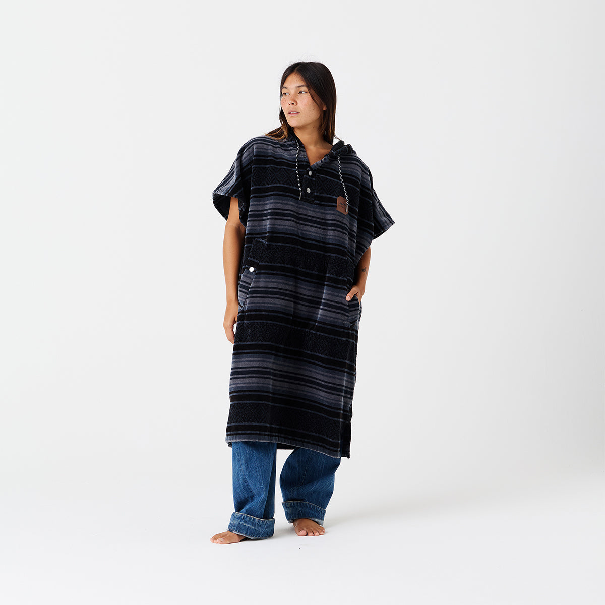 Terry poncho with oversized fit styled over blue jeans.