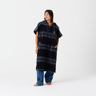Terry poncho with oversized fit styled over blue jeans.