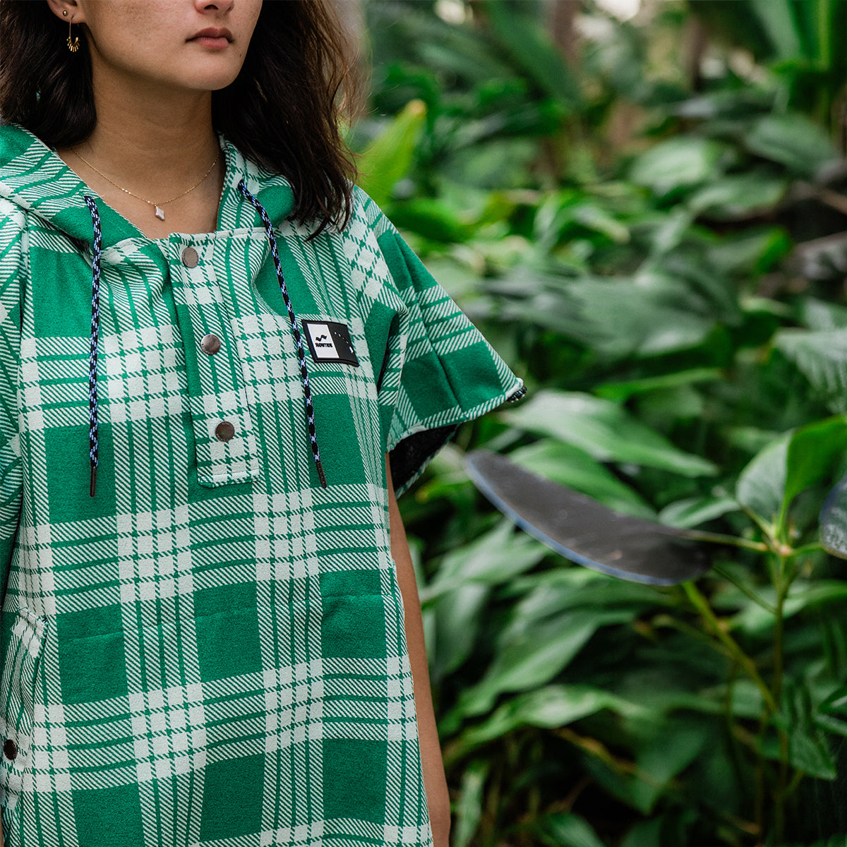 Green plaid dress in sustainable fabric with checked pattern, outdoor setting.