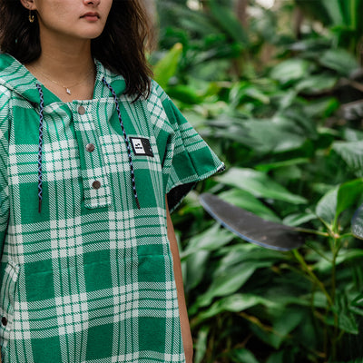 Green plaid dress in sustainable fabric with checked pattern, outdoor setting.