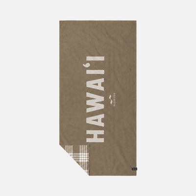 Brown quick-dry towel with white text and plaid corner accent.