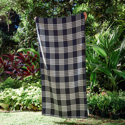 Sustainable towel with large size, shown outdoors among lush green plants.