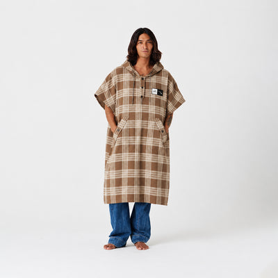 Hooded poncho in brown plaid recycled fabric with a front pocket and button placket.
