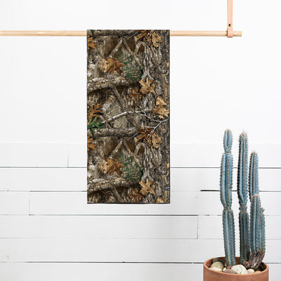 Camo quick-dry towel with woodland pattern hanging on a wooden rod.