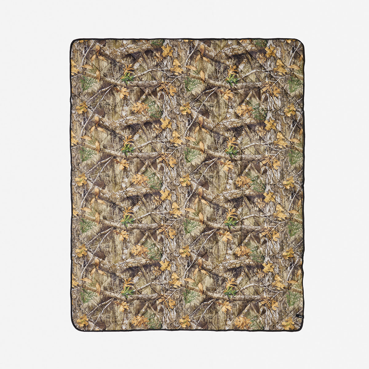 Quilted packable blanket with photorealistic camo print on white background.