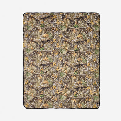 Quilted packable blanket with photorealistic camo print on white background.