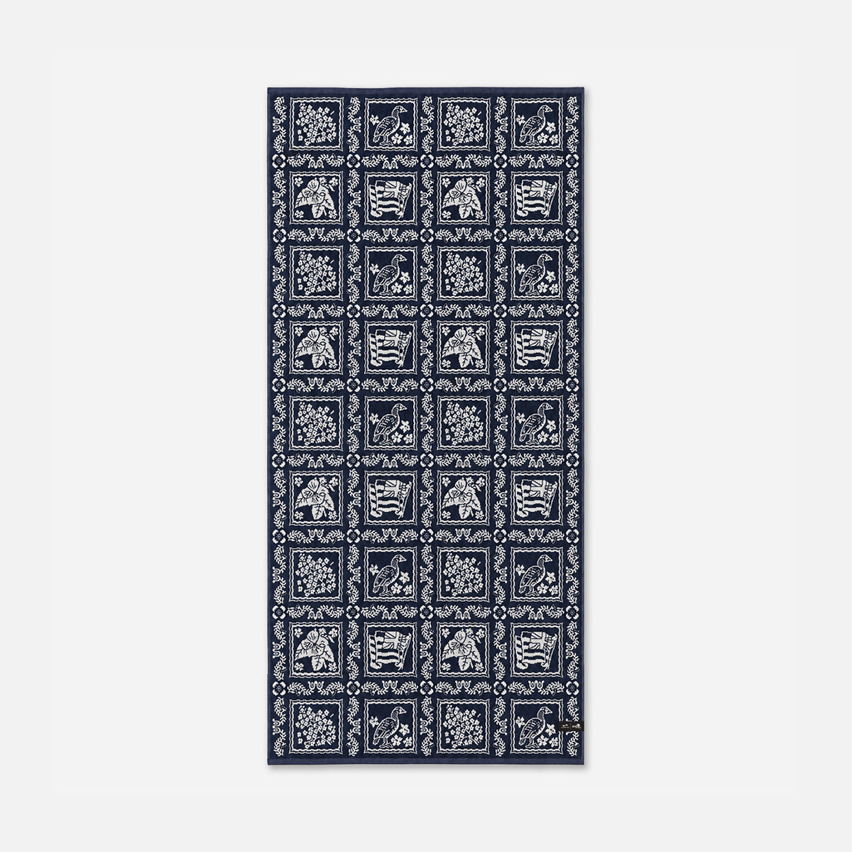 Navy cotton towel with jacquard weave, white animal and floral squares in grid pattern.