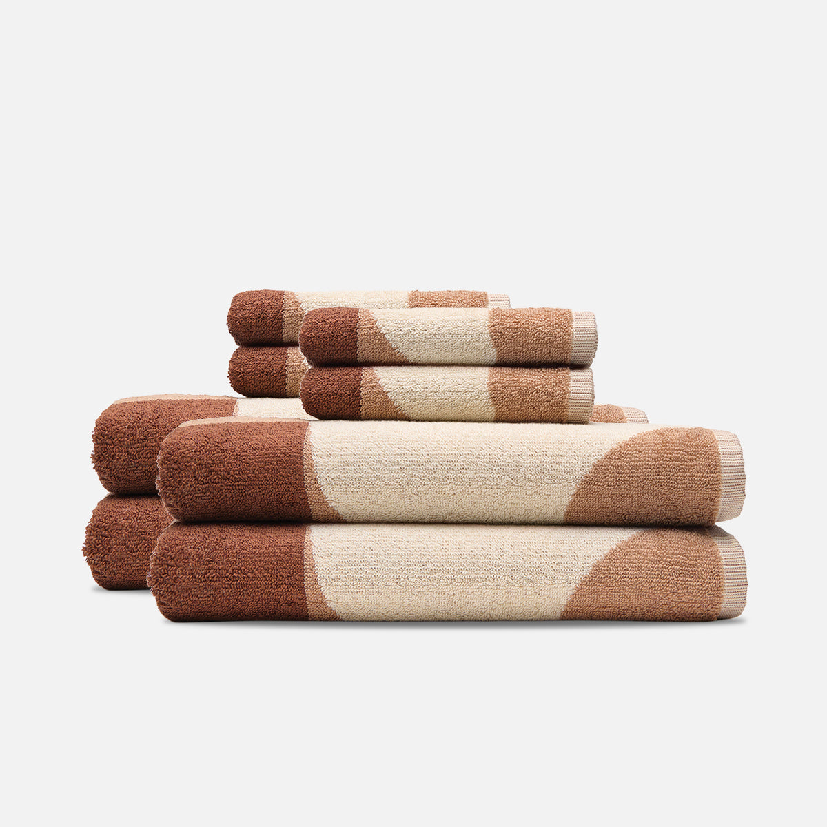 Sand-resistant bath towels stacked with a brown and beige circular pattern.