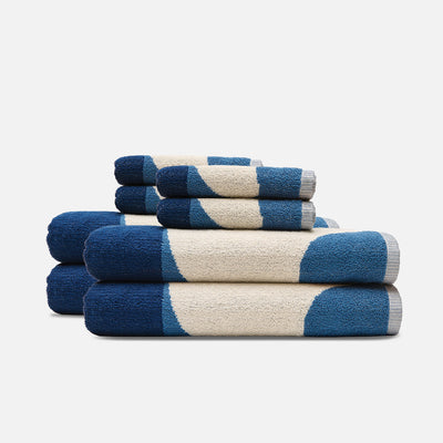 Cotton beach towels stacked with blue and cream circular pattern.