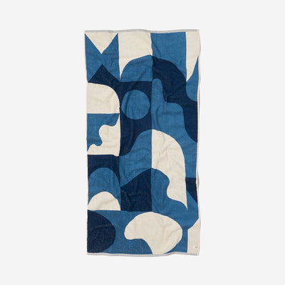Oversized towel with a blue and cream abstract geometric pattern.