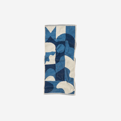 Towel poncho in sand-resistant fabric with blue and cream abstract geometric pattern.