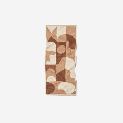 Oversized cotton hand towel featuring a brown and cream geometric abstract pattern.