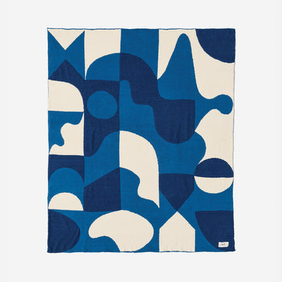 Reversible knit throw blanket in plush recycled fabric with a blue and white geometric pattern.