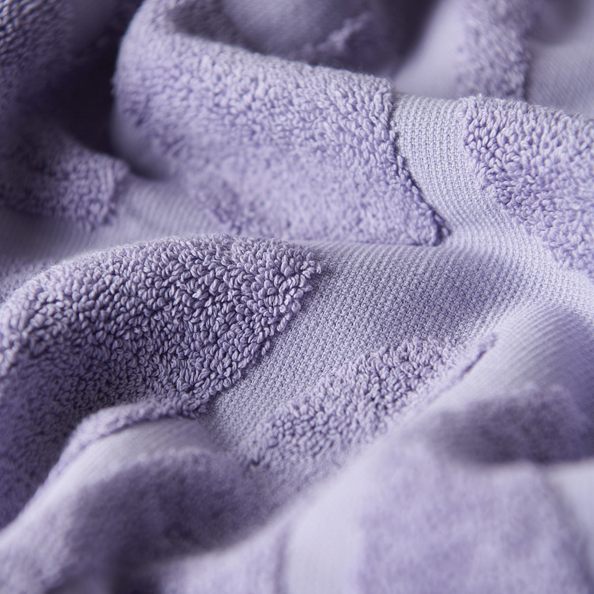 Lavender velour towel with textured folds and absorbent visible loops.