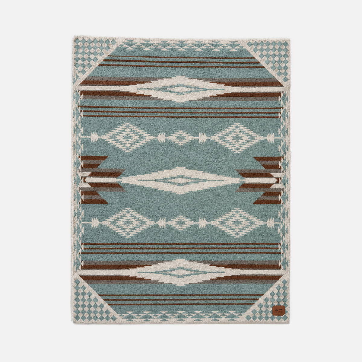 Rug with blue and brown diamond geometric pattern, suitable for layering under throws.