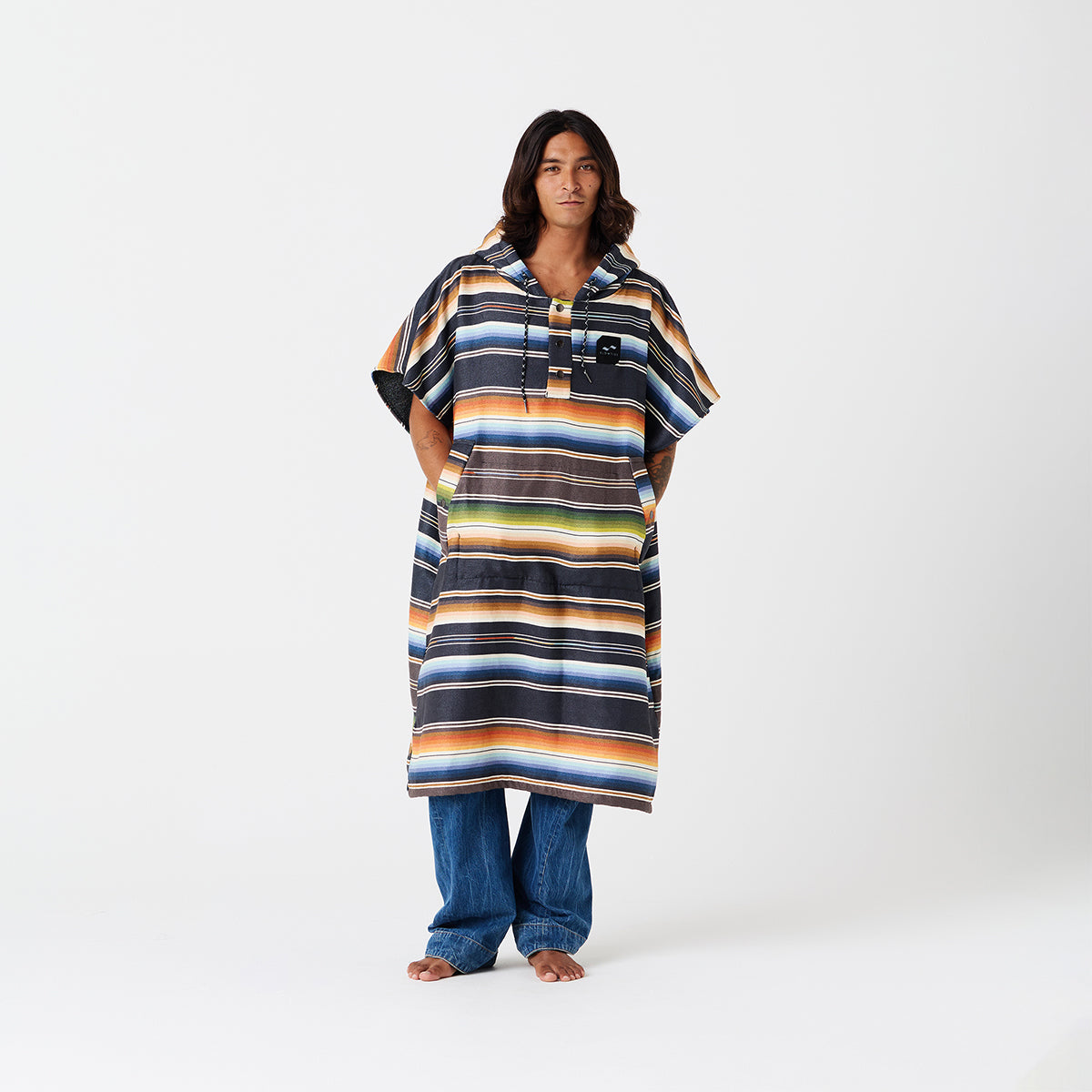 Striped, sand-resistant quick-dry changing poncho over jeans.