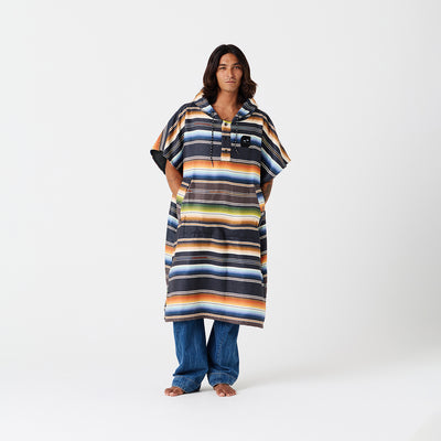 Striped, sand-resistant quick-dry changing poncho over jeans.