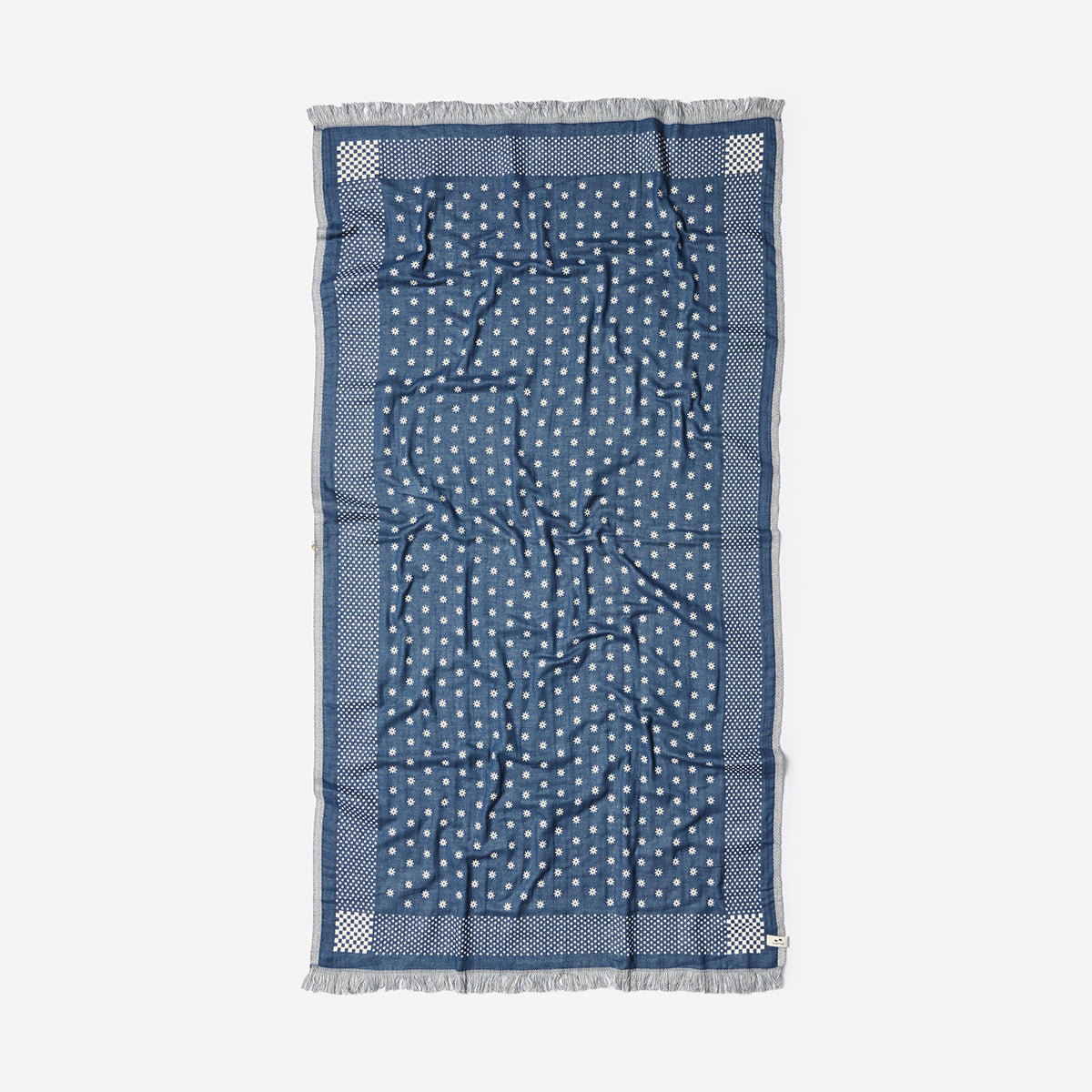 Blue lightweight scarf with white polka dots and fringed edge.