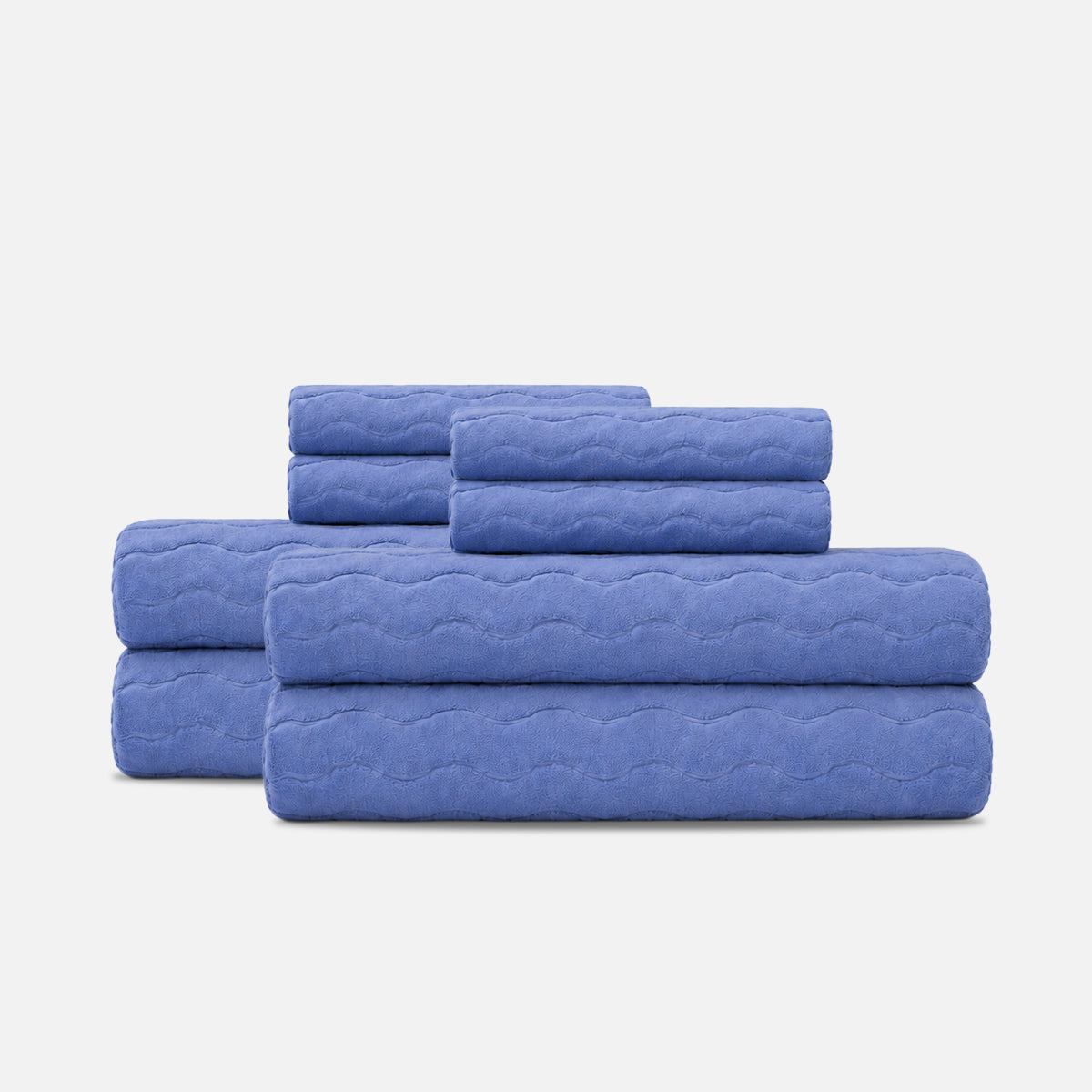 Plush cotton bath towels in a stacked set with a sculpted wave texture.