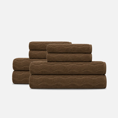 Brown bath towel set in plush cotton with a sculpted wave texture.